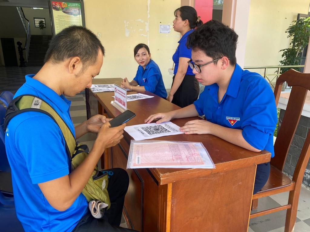 Người dân được các đoàn viên thanh niên hướng dẫn chọn nội dung thủ tục cần hỗ trợ rồi thao tác trên máy để lấy số thứ tự
