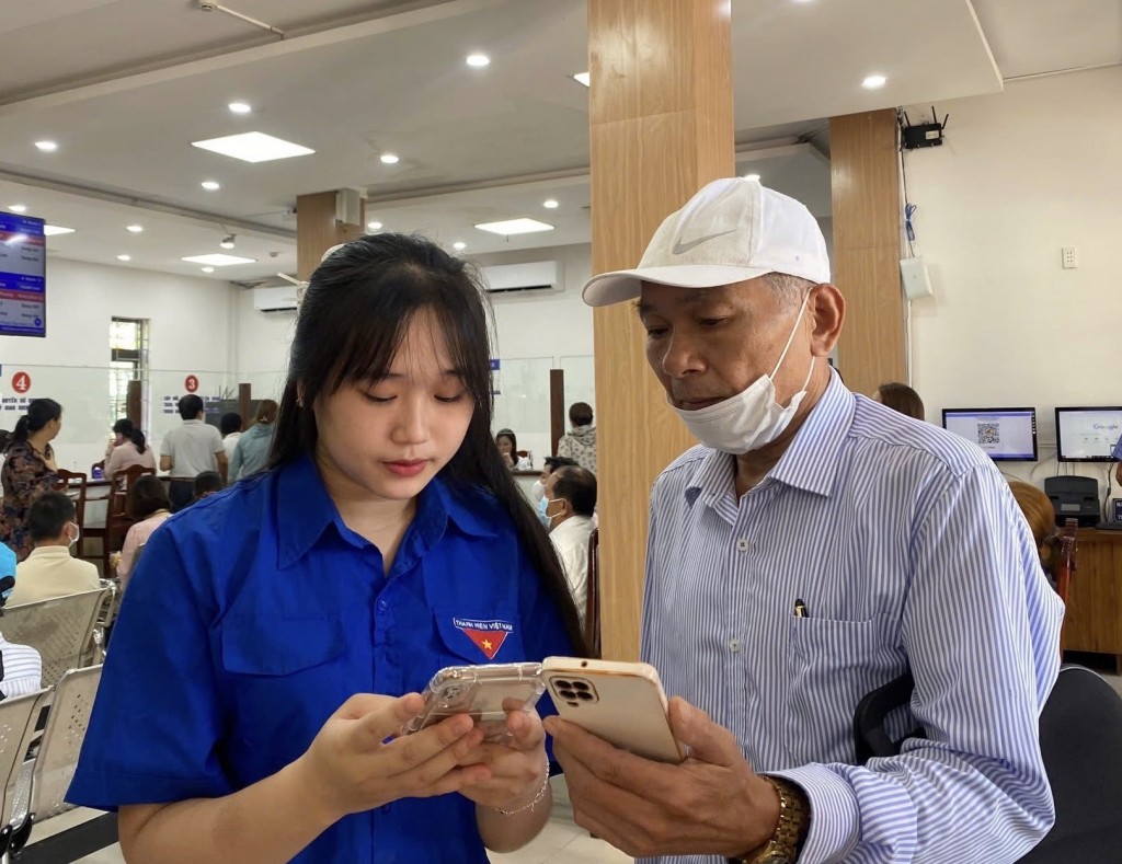 Nhiều người dân lớn tuổi hài lòng khi được các bạn trẻ tận tình hướng dẫn thực hiện thủ tục hành chính điện tử