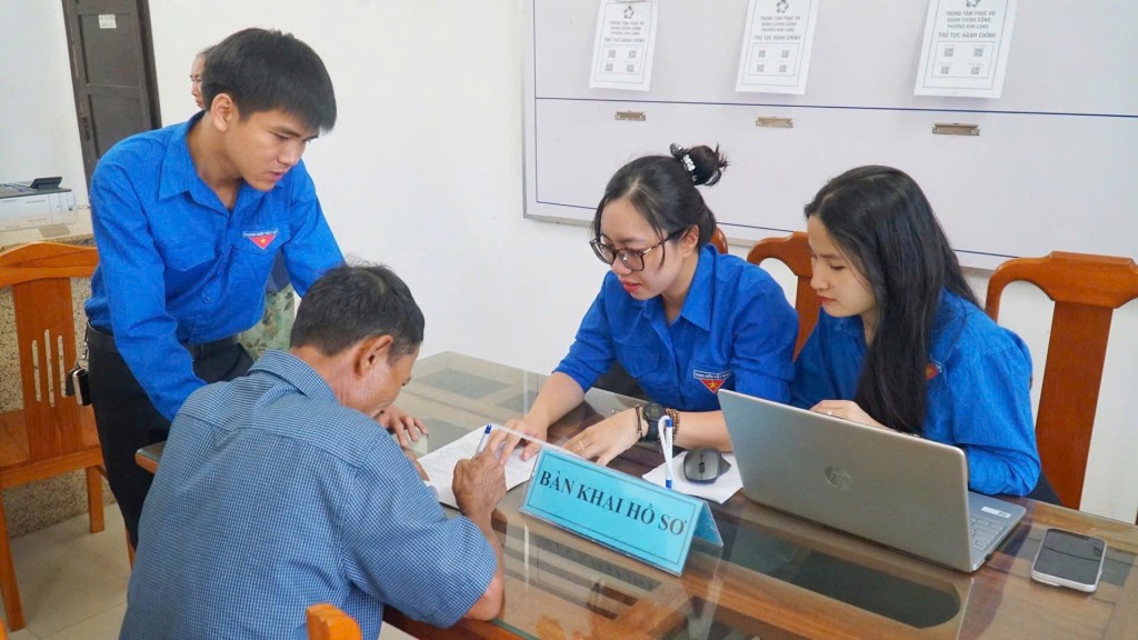 Tình nguyện viên hỗ trợ người dân đến giải quyết thủ tục hành chính 