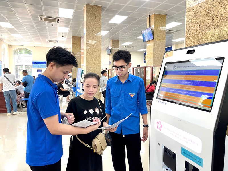 Bạn Phạm Văn Quyết và Nguyễn Đình Thông hướng dẫn công dân đến làm thủ tục hành chính