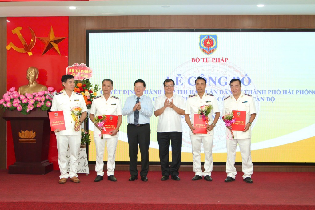 Thứ trưởng Bộ Tư pháp Mai Lương Khôi và Phó Chủ tịch UBND thành phố Nguyễn Minh Hùng trao Quyết định và tặng hoa chúc mừng.