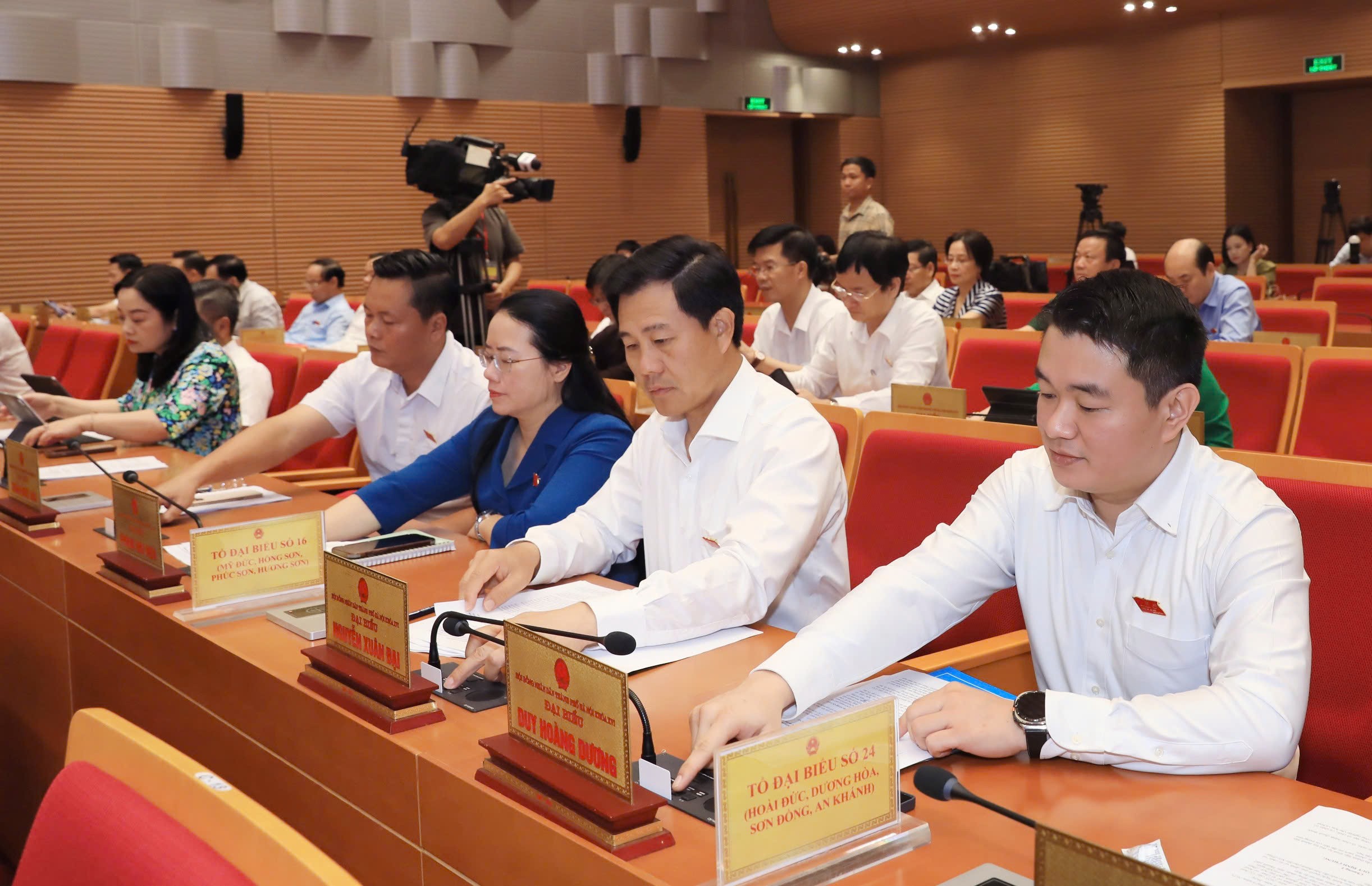 Các đại biểu tham gia biểu quyết thông qua nội dung nghị quyết