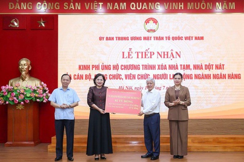 Thống đốc Nguyễn Thị Hồng trao biển tượng trưng kinh phí ủng hộ chương trình xóa nhà tạm, nhà dột nát của ngành Ngân hàng đến Chủ tịch Ủy ban Trung ương MTTQ Việt Nam.