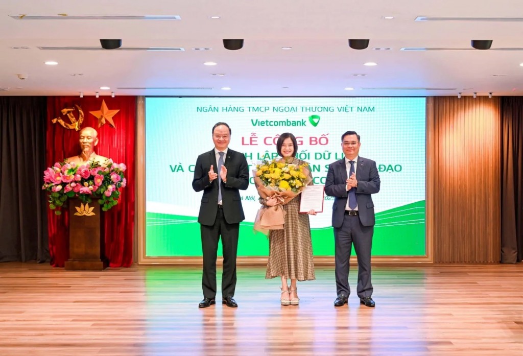 Ông Nguyễn Thanh Tùng - Chủ tịch HĐQT (bên phải) trao Quyết định và ông Lê Quang Vinh - Thành viên HĐQT, Tổng Giám đốc (bên trái) tặng hoa chúc mừng bà Phùng Nguyễn Hải Yến - Phó Tổng Giám đốc, tân Giám đốc Khối Dữ liệu