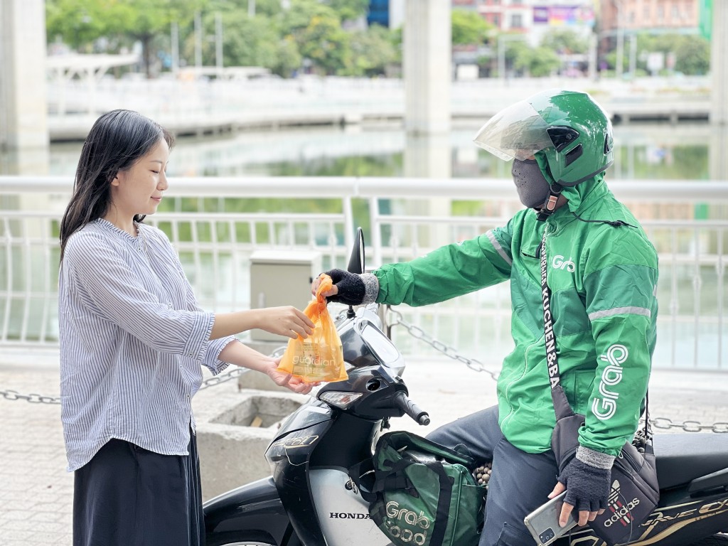 Người dùng nhận hàng GrabMart từ đối tác tài xế