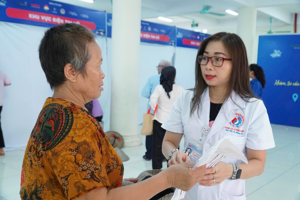 Thạc sĩ điều dưỡng Tạ Hồng Liên (Bệnh viện Y học cổ truyền Trung ương) hướng dẫn người dân đi khám