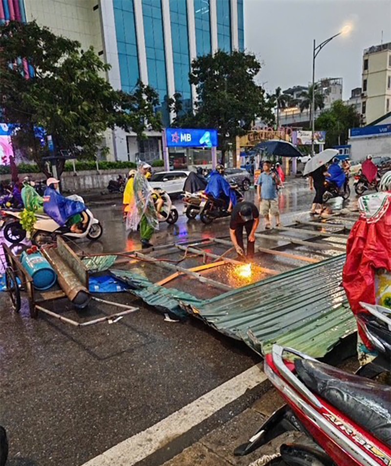 Một tấm biển quảng cáo bị kéo đổ văng ra đường, và lực lượng chức năng đã có mặt để xử lý Một tấm biển quảng cáo bị kéo đổ văng ra đường, và lực lượng chức năng đã có mặt để xử lý