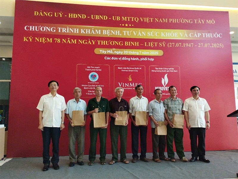 Đồng chí Trần Quang Dũng - Phó Bí thư Thường trực Đảng uỷ Tập đoàn Công nghiệp năng lượng Quốc gia Việt Nam và đồng chí Trần Thanh Hải - Phó Bí thư Đảng uỷ, Chủ tịch UBND phường Tây Mỗ trao quà cho các bác thương, bệnh binh, người có công, gia đình liệt sỹ trên địa bàn 