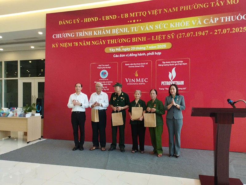 Đồng chí Nguyễn Đình Hưng - Phó Giám đốc phụ trách Sở Y tế Hà Nội và đồng chí Hoàng Thị Thuý Hằng - Bí thư Đảng uỷ, Chủ tịch HĐND phường Tây Mỗ trao quà cho các bác thương, bệnh binh, người có công, gia đình liệt sỹ