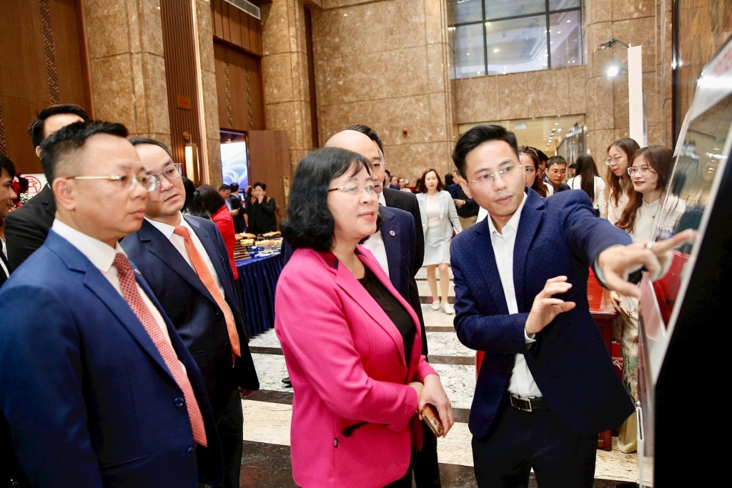 Bí thư Thành ủy Hà Nội Bùi Thị Minh Hoài trải nghiệm các ứng dụng chuyển đổi số dùng chung 3 cấp của thành phố tại hội nghị.