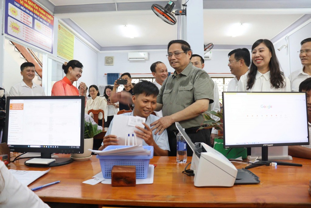 Thủ tướng Phạm Minh Chính thăm hỏi người dân làm thủ tục ở Trung tâm Phục vụ Hành chính công của phường Thới Sơn (ảnh: Như Ngọc)