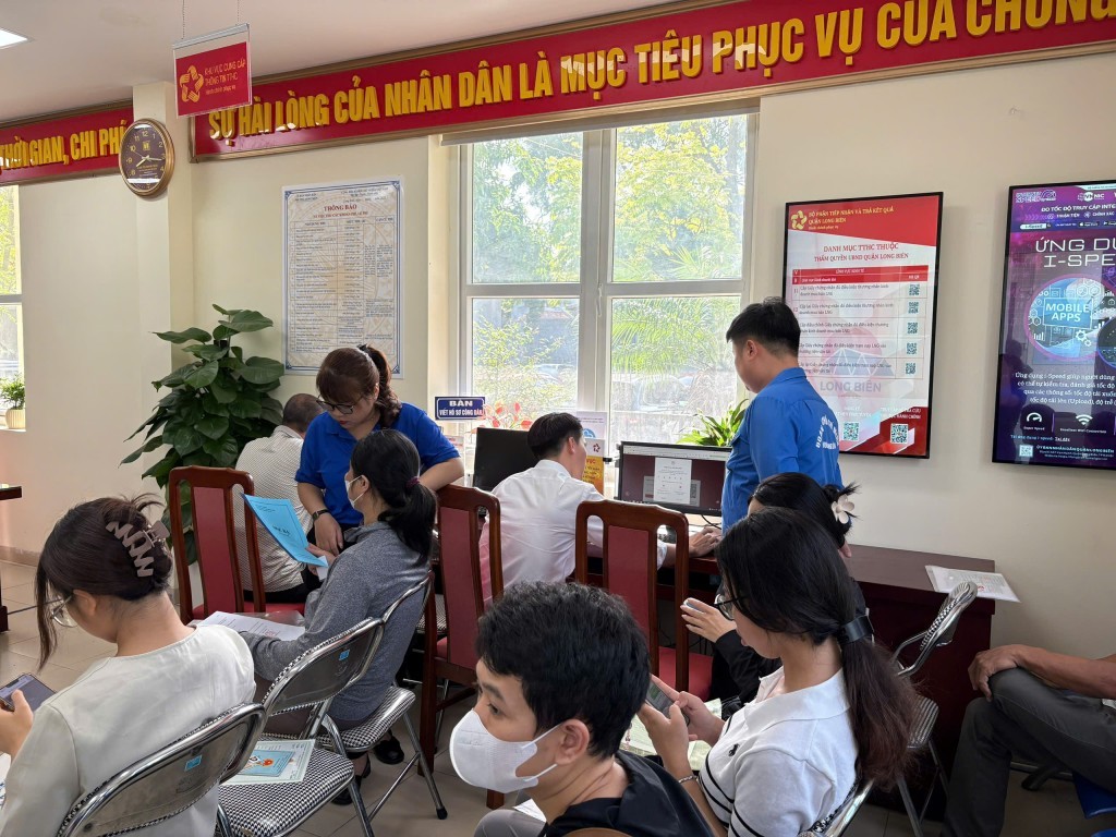 Các đoàn viên của Đoàn TNCS Hồ Chí Minh phường Long Biên hướng dẫn người cao tuổi thực hiện thao tác trên máy tính