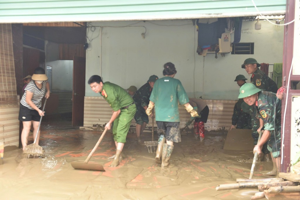 Các lực lượng chức năng hỗ trợ người dân vệ sinh môi trường, từng bước ổn định đời sống - Ảnh: VGP/Giang Thanh