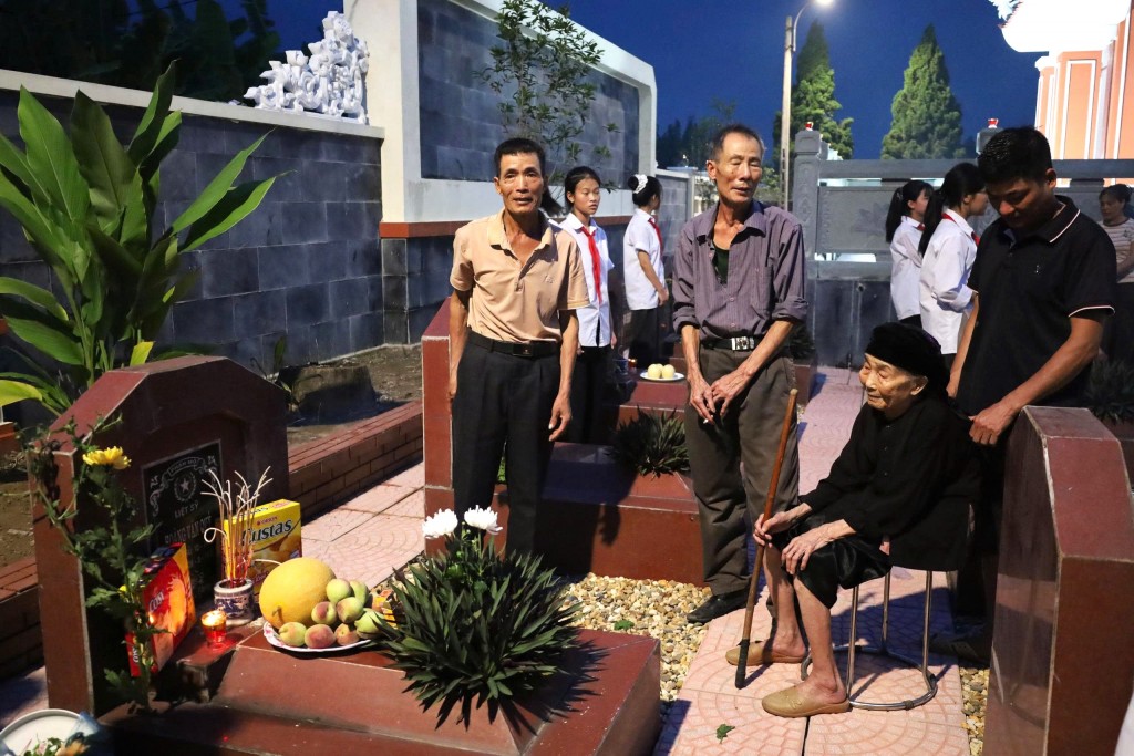 Người mẹ ngồi bên nơi an nghỉ của liệt sỹ