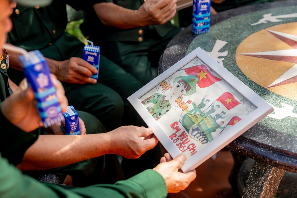 Các bác cựu chiến binh chăm chú đọc những dòng chữ nhỏ, được các em gửi kèm trong mỗi bức tranh (Ảnh: Duy Cường).