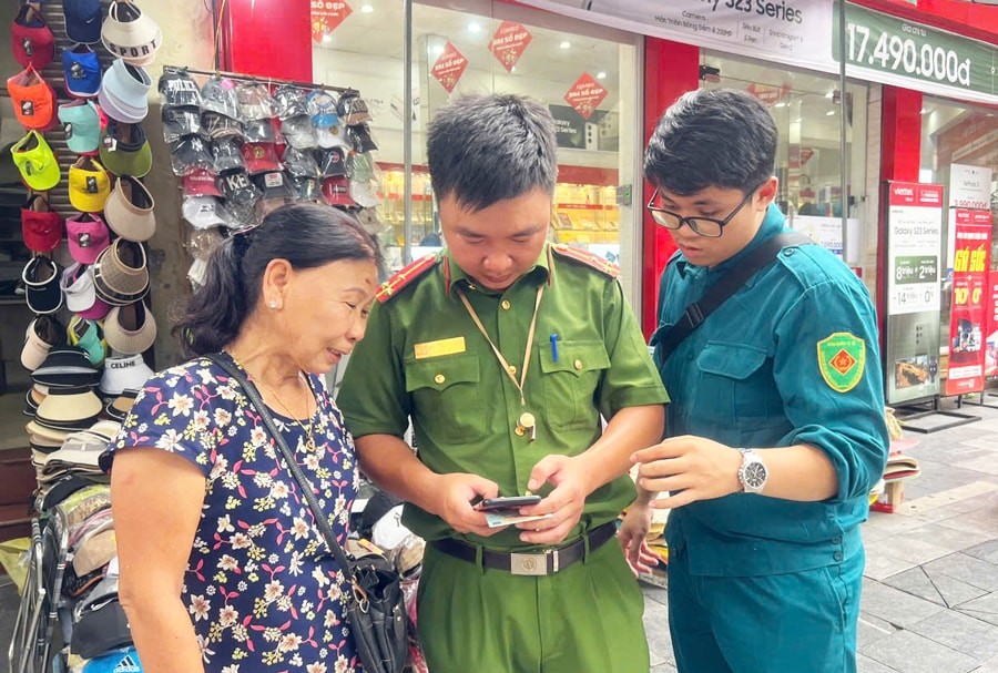 Công an phường Hàng Bạc (quận Hoàn Kiếm) hướng dẫn người dân cập nhật các ứng dụng trên điện thoại thông minh.