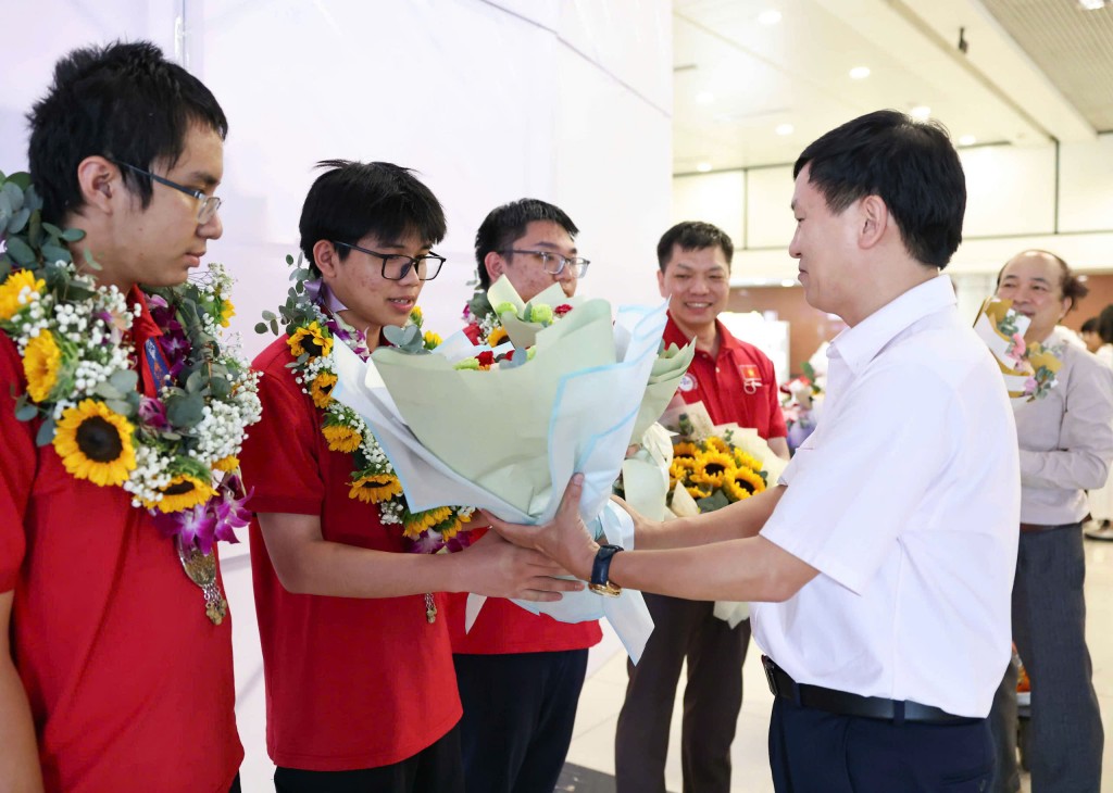 Đại diện Bộ GD&ĐT tặng hoa chúc mừng đoàn. (Ảnh: Thanh Tùng)