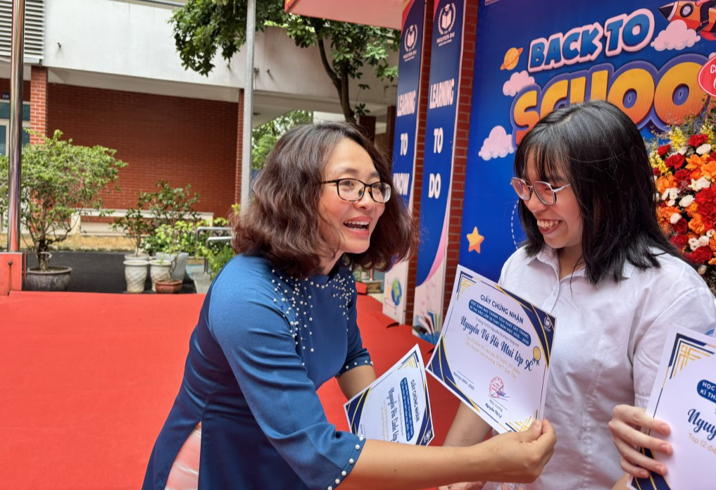 Cô Nguyễn Thị Lý - Hiệu trưởng trường THCS Nguyễn Du tặng giấy khen vinh danh học sinh có thành tích xuất sắc trong kỳ thi vào lớp 10