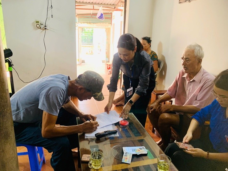 Cán bộ xã Quảng Bị đến tận nhà hỗ trợ người dân làm các thủ tục hưởng trợ cấp hưu trí xã hội 