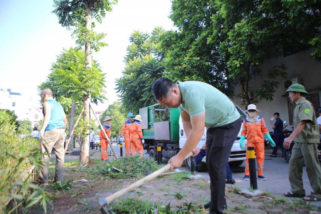 Bạn Nguyễn Duy Khánh, cán bộ Văn phòng UBND phường Phúc Lợi dọn dẹp môi trường