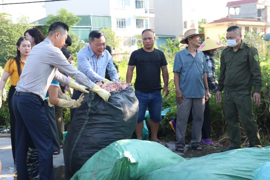 Đồng chí Nguyễn Văn Phong, Phó Bí thư Thường trực Thành ủy Hà Nội và đồng chí Nguyễn Xuân Thanh, Bí thư xã Phú Xuyên, cùng người dân dọn dẹp vệ sinh môi trường sau lễ phát động