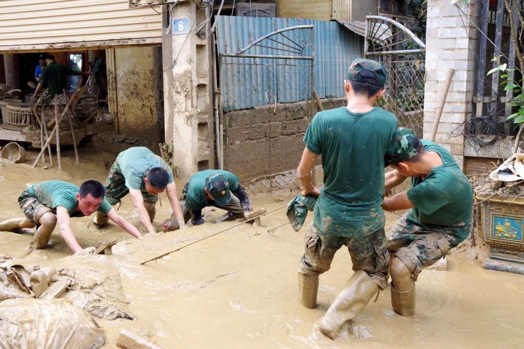 Lực lượng Sư đoàn 324 hỗ trợ người dân xã Tương Dương khắc phục hậu quả mưa lũ. Ảnh: TTXVN
