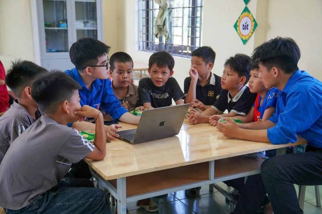 Các bạn sinh viên tình nguyện dạy các em nhỏ về AI tại lớp “Bình dân học vụ số” ở nhà văn hoá xóm Nà Canh, xã Dân Tiến, tỉnh Thái Nguyên