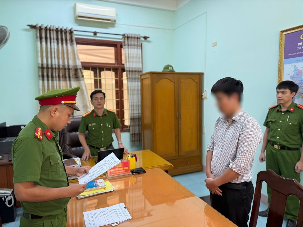 Cơ quan cảnh sát điều tra Công an tỉnh Quảng Ngãi tống đạt quyết định khởi tố một trong ba bị can liên quan đến vụ án ( Ảnh: Công an Quảng Ngãi)