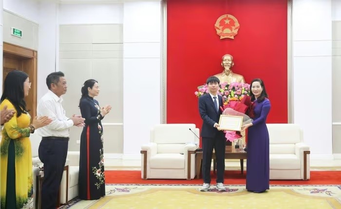 Bà Nguyễn Thị Hạnh, Phó chủ tịch UBND tỉnh Quảng Ninh trao thưởng cho em Ninh Quang Thắng do đạt thành tích cao tại kỳ thi Olympic Tin học Quốc tế.