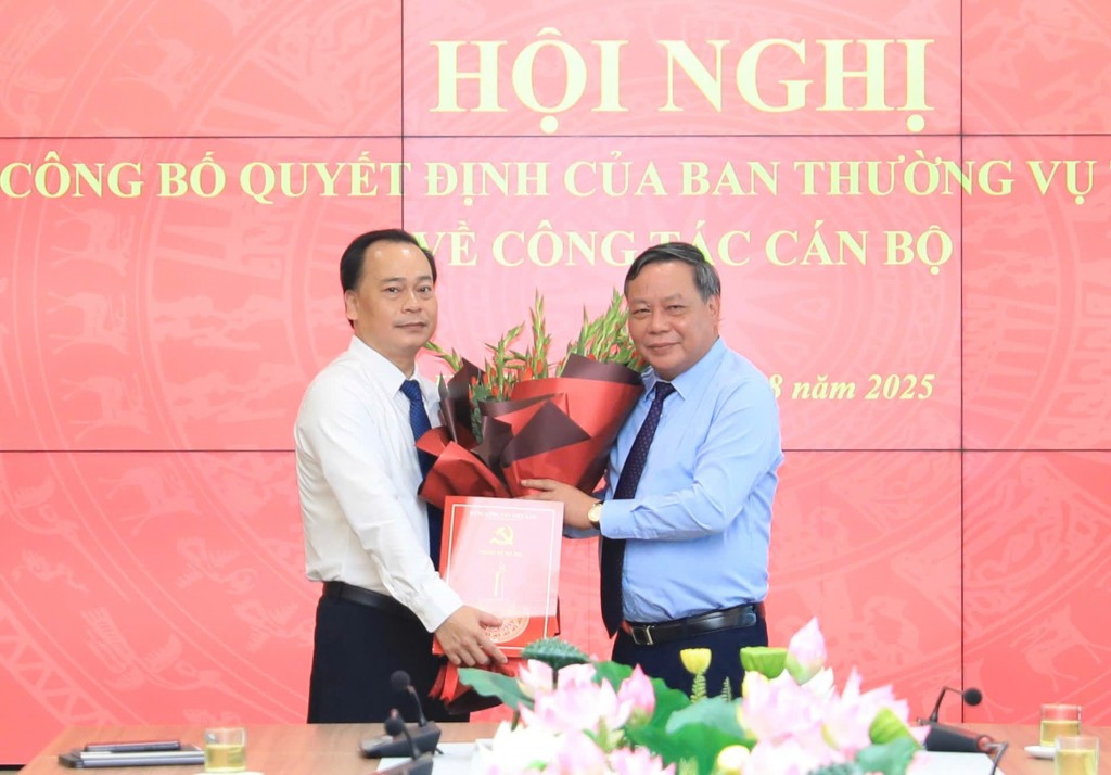 Phó Bí thư Thường trực Thành ủy Nguyễn Văn Phong trao Quyết định của Ban Thường vụ Thành ủy và tặng hoa chúc mừng đồng chí Nguyễn Mạnh Quân. Ảnh: Quang Thái