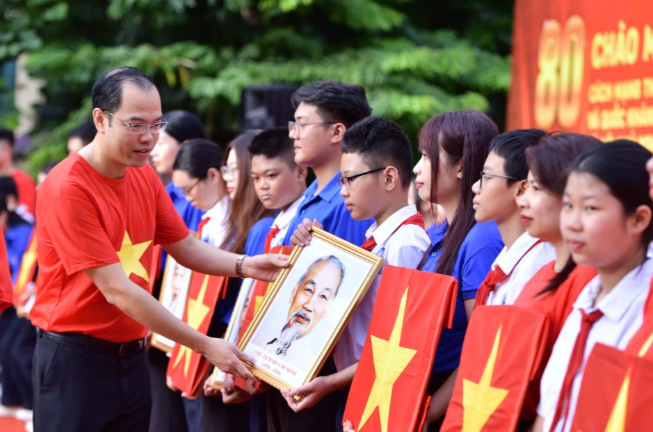 anh Nguyễn Tiến Hưng, Uỷ viên Ban Chấp hành Trung ương Đoàn, Bí thư Thành đoàn, Chủ tịch Hội Sinh viên Việt Nam thành phố Hà Nội tặng cờ Tổ quốc và ảnh Bác Hồ tới đoàn viên, thiếu niên