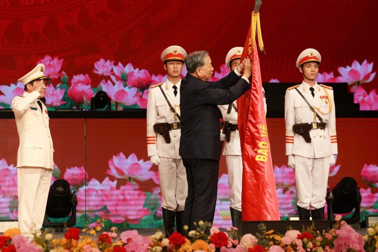 Tổng Bí thư Tô Lâm gắn Huân chương Sao vàng lên lá cờ truyền thống của lực lượng Công an nhân dân. Ảnh: Nhật Nam