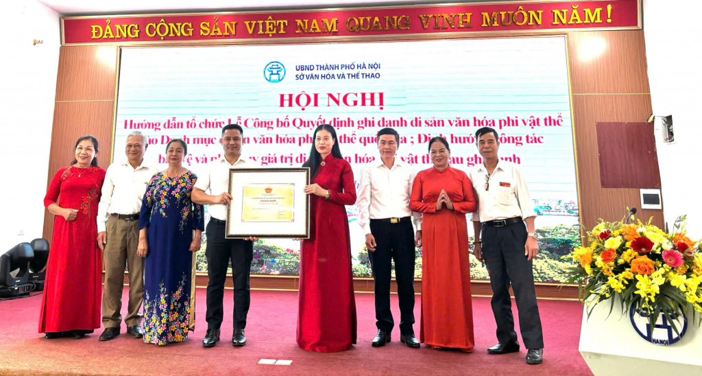 Lãnh đạo xã Ô Diên và nghệ nhân Hội hát Chèo Tàu Tổng Gối (xã Tân Hội, huyện Đan Phượng - nay là xã Ô Diên) đón nhận chứng nhận Di sản văn hóa phi vật thể quốc gia