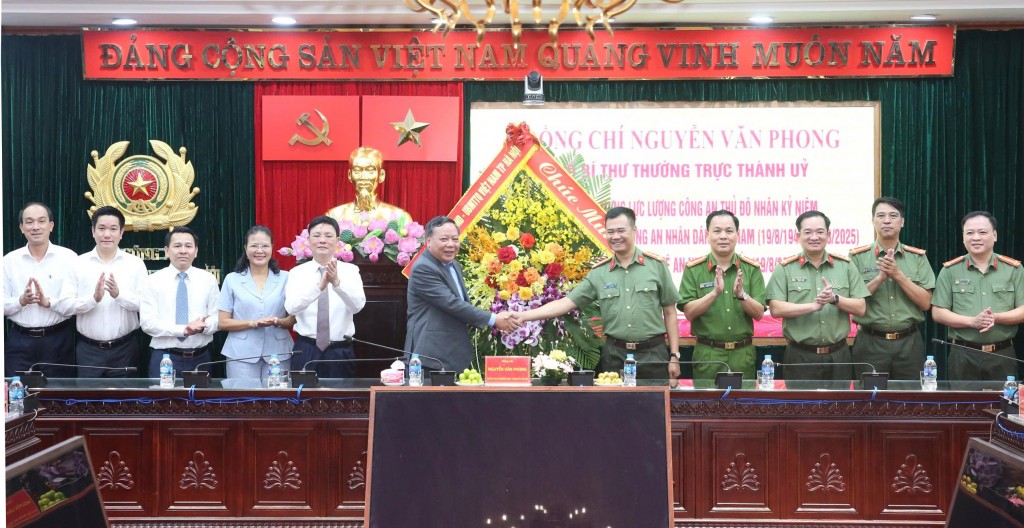 Phó Bí thư Thường trực Thành ủy Hà Nội Nguyễn Văn Phong tặng hoa chúc mừng Công an thành phố Hà Nội. 