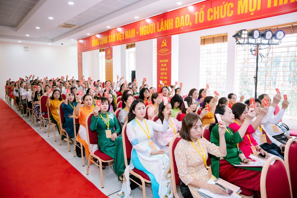 Các đại biểu biểu quyết thông qua các nội dung bằng hình thức giơ thẻ Đảng