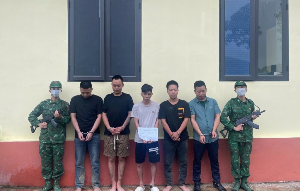 Đối tượng Lê Văn Hiệp (đứng giữa) cùng các công dân Trung Quốc bị bắt giữ tại Đồn Biên phòng cửa khẩu quốc tế Trà Lĩnh. Ảnh: Huy Dương