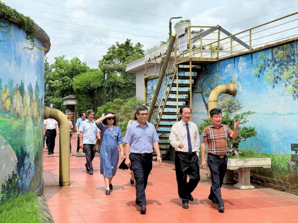 Ông Phạm Hồng Điệp dẫn đoàn tham quan mô hình nhà máy nước thải trong khuôn viên vườn Nhật