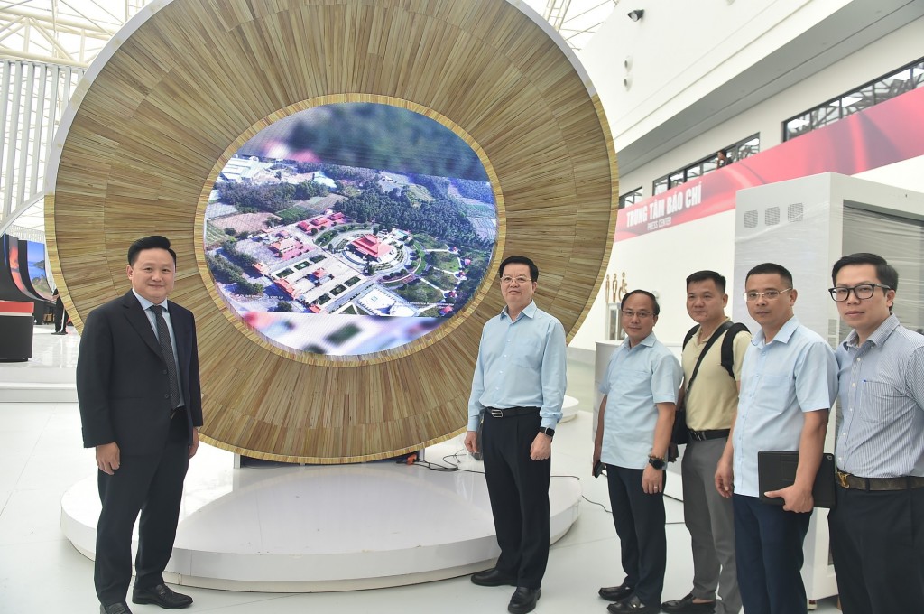 Phó Thủ tướng Mai Văn Chính và Phó Tổng Biên tập Báo Nhân Dân Phan Văn Hùng tại một gian hàng Triển lãm.