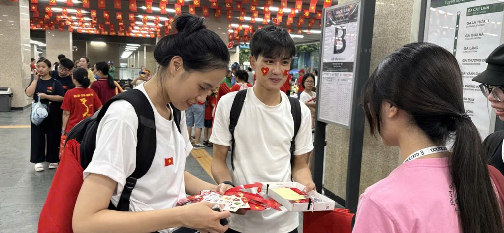 Những tiểu thương tranh thủ bán cờ đỏ, sticker ngay tại lối vào ga, tiếp thêm sắc đỏ rực rỡ.