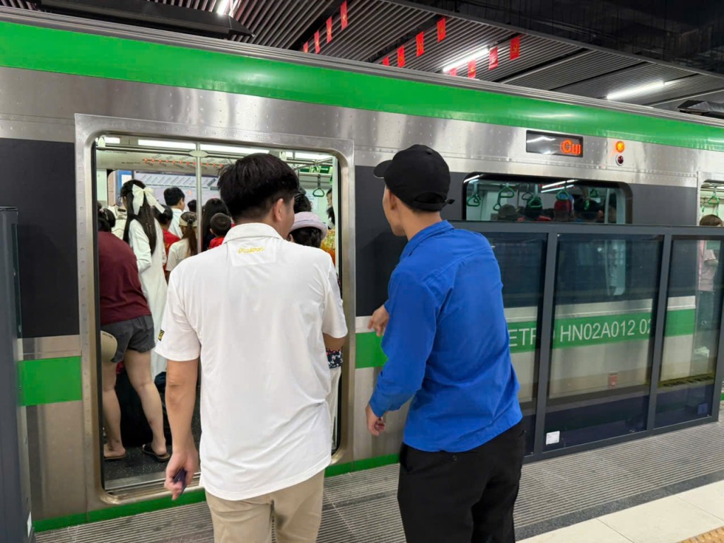 Các bạn đoàn viên, thanh niên tình nguyện tiếp sức, dìu cụ già và trẻ nhỏ lên thang cuốn an toàn.