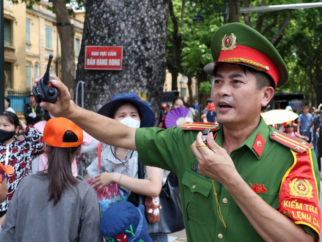 Công an phát loa kêu gọi người dân giữ gìn trật tự. Ảnh: MH