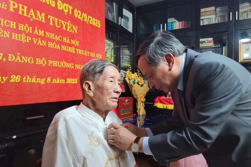 Phó Bí thư Thường trực Thành ủy Hà Nội Nguyễn Văn Phong trao Huy hiệu 75 năm tuổi Đảng tặng nhạc sĩ Phạm Tuyên. Ảnh: MH