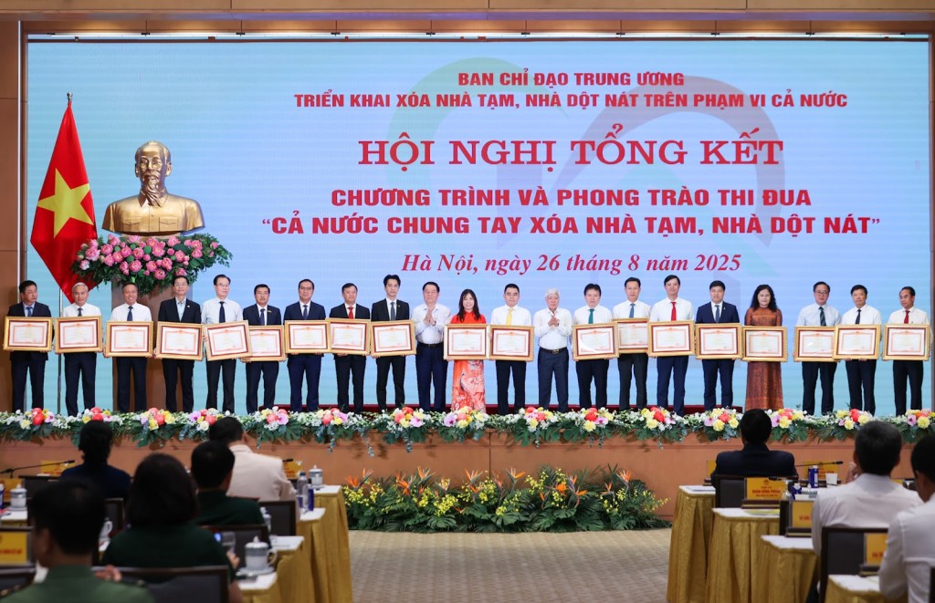 Chủ tịch Uỷ ban Trung ương MTTQ Việt Nam Đỗ Văn Chiến và Trưởng Ban Tuyên giáo và Dân vận Trung ương Nguyễn Trọng Nghĩa trao Bằng khen của Thủ tướng Chính phủ cho các tập thể có thành tích xuất sắc trong Phong trào thi đua “Cả nước chung tay xóa nhà tạm, nhà dột nát” - Ảnh: VGP/Nhật Bắc
