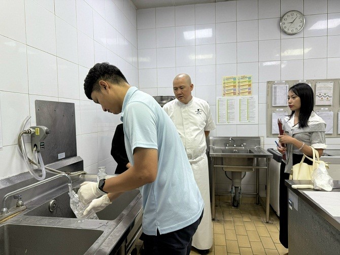 Đoàn công tác thực hiện lấy mẫu nước tại vòi bếp chính của khách sạn theo đúng quy trình kỹ thuật.