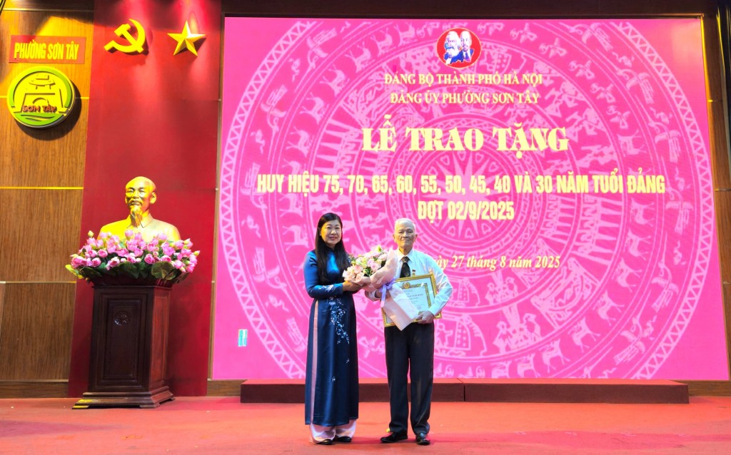 Chủ tịch Ủy ban MTTQ Việt Nam thành phố Hà Nội Nguyễn Lan Hương trao Huy hiệu 70 năm tuổi Đảng tặng đảng viên Nguyễn Ngọc Tuyên, sinh năm 1933, Chi bộ tổ dân phố 2, Đảng bộ phường Sơn Tây. 