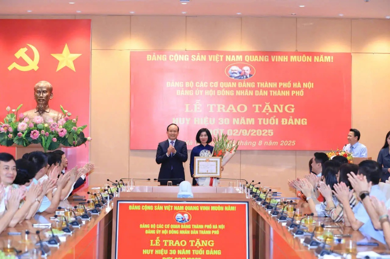 Đồng chí Nguyễn Ngọc Tuấn trao Huy hiệu, chúc mừng đồng chị Phùng Thị Hồng Hà