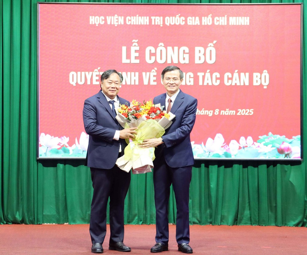 PGS.TS Đoàn Minh Huấn, Ủy viên Trung ương Đảng, Phó Giám đốc Thường trực Học viện Chính trị Quốc gia Hồ Chí Minh trao hoa tri ân PGS.TS Nguyễn Quốc Dũng, Giám đốc Học viện Chính trị khu vực II (bên trái). Ảnh: Đặng Hùng