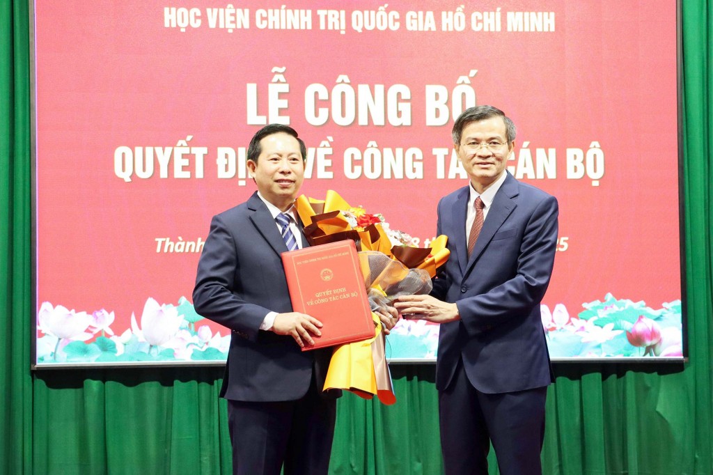 PGS.TS Đoàn Minh Huấn, Ủy viên Trung ương Đảng, Phó Giám đốc Thường trực Học viện Chính trị Quốc gia Hồ Chí Minh trao quyết định bổ nhiệm Giám đốc Học viện Chính trị khu vực II cho PGS.TS Nguyễn Tấn Vinh (bên trái). Ảnh: Đặng Hùng