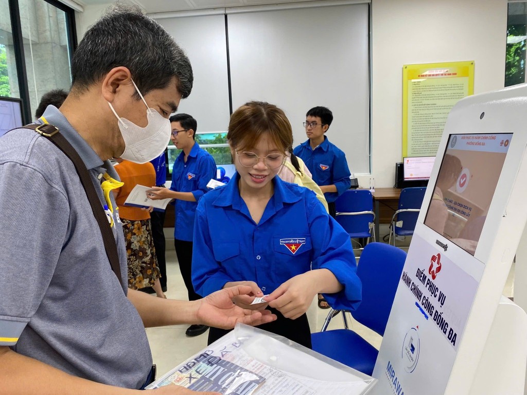 Tuổi trẻ phường Đống Đa hỗ trợ người dân lấy vé tại kiot tự động Điểm phục vụ hành chính công phường Đống Đa.