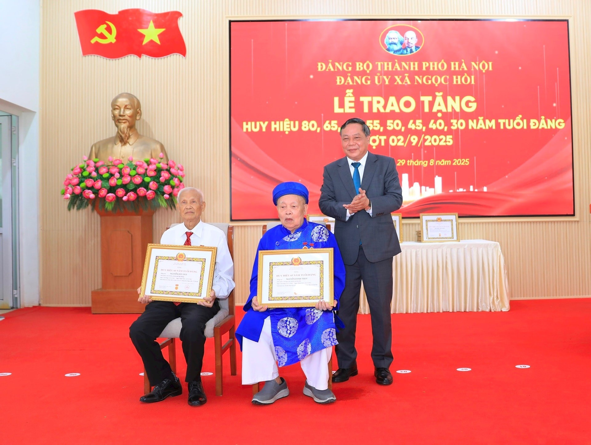 Phó Bí thư Thường trực Thành ủy Hà Nội Nguyễn Văn Phong trao Huy hiệu 65, 60 năm tuổi Đảng tặng các đảng viên lão thành của xã Ngọc Hồi. Ảnh: Quang Thái